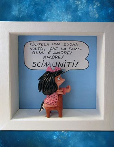 Statuina di terracotta del fumetto Mafalda all'interno di una cornice di legno massello bianca, con scritta :