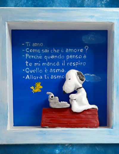 Statuina di terracotta del fumetto Snoopy all'interno di una cornice di legno massello bianca con scritta sul fondo dipinta con colori acrilici. Fatto a mano